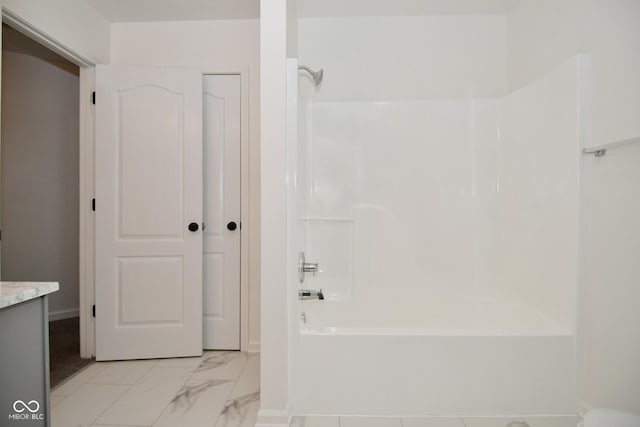 bathroom featuring marble finish floor, shower / bath combination, and vanity