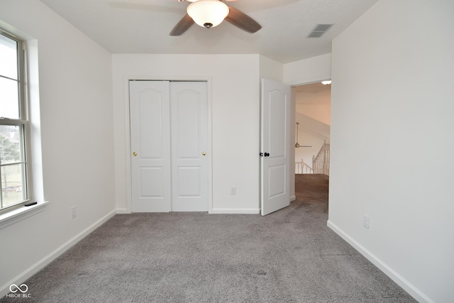 unfurnished bedroom with visible vents, baseboards, ceiling fan, carpet, and a closet