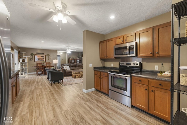 kitchen featuring dark countertops, brown cabinetry, light wood-style flooring, and stainless steel appliances