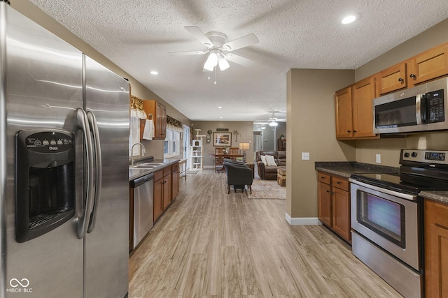 kitchen featuring dark countertops, brown cabinetry, light wood-style flooring, and stainless steel appliances