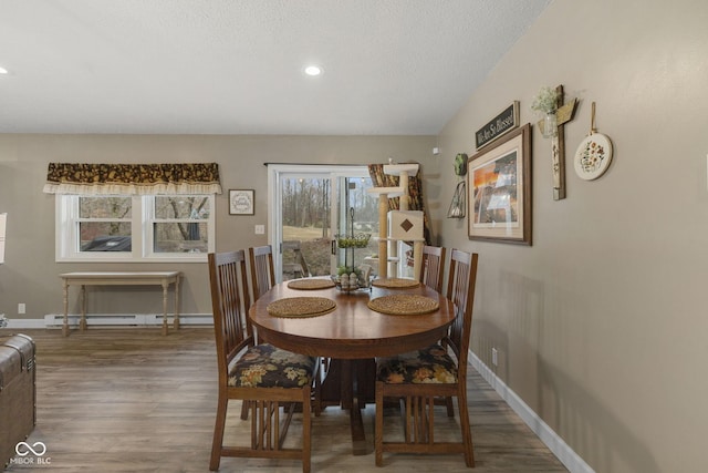 dining area with a baseboard radiator, recessed lighting, a textured ceiling, wood finished floors, and baseboards