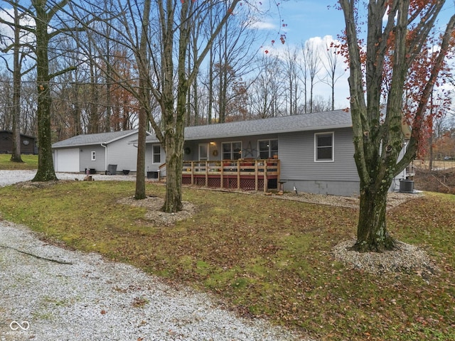 ranch-style house featuring a garage, central air condition unit, and a wooden deck