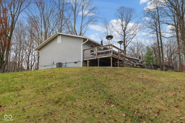 back of property featuring crawl space, central AC unit, a deck, and a lawn