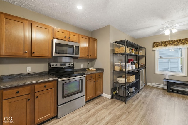 kitchen with appliances with stainless steel finishes, brown cabinets, and light wood finished floors