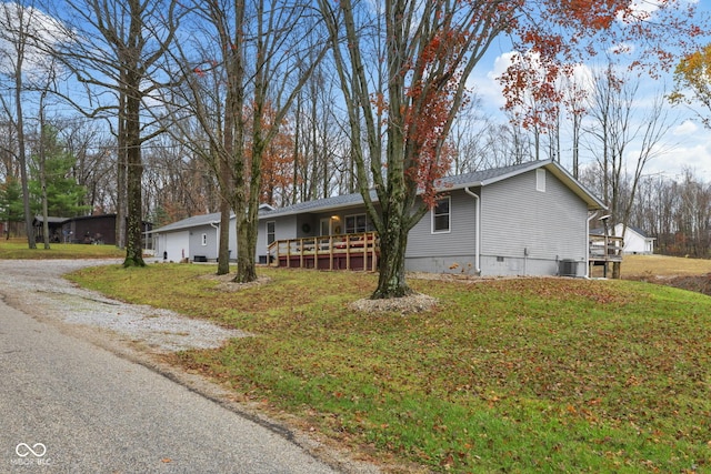 ranch-style home featuring cooling unit, a garage, crawl space, a wooden deck, and a front lawn