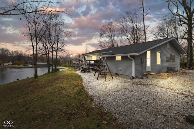 back of property featuring a shingled roof, crawl space, and a water view