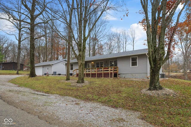 single story home featuring a deck, driveway, roof with shingles, and cooling unit