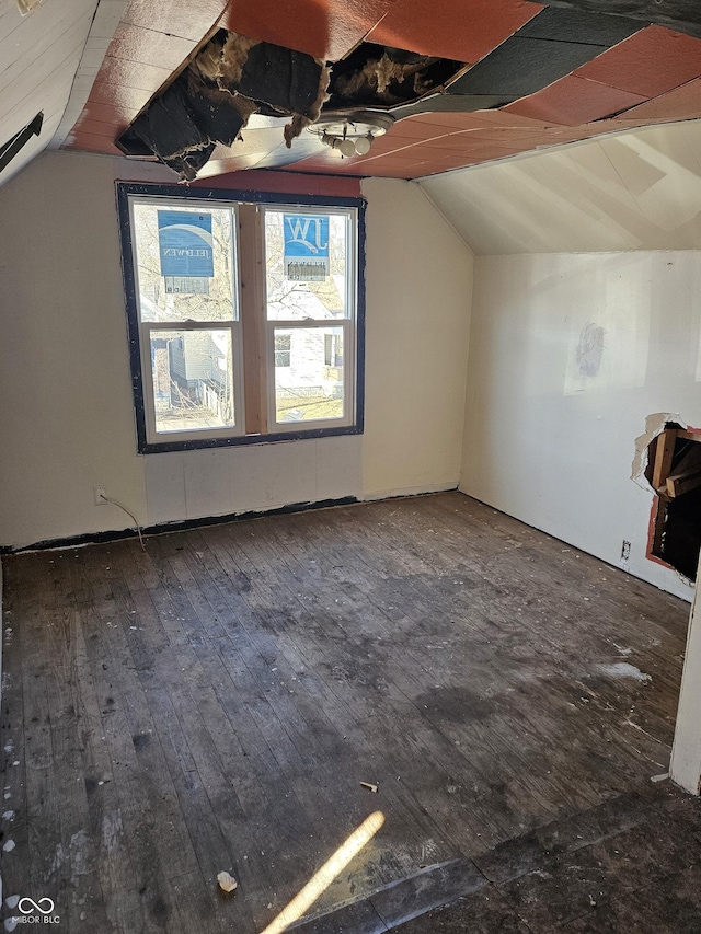 additional living space featuring dark wood-style floors and vaulted ceiling