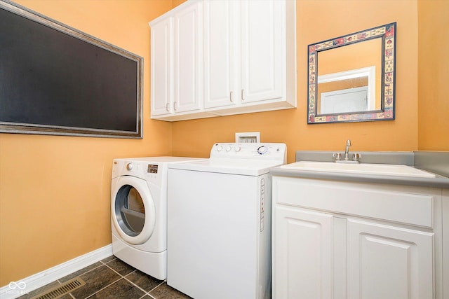 laundry area with cabinet space, baseboards, a sink, and washing machine and clothes dryer