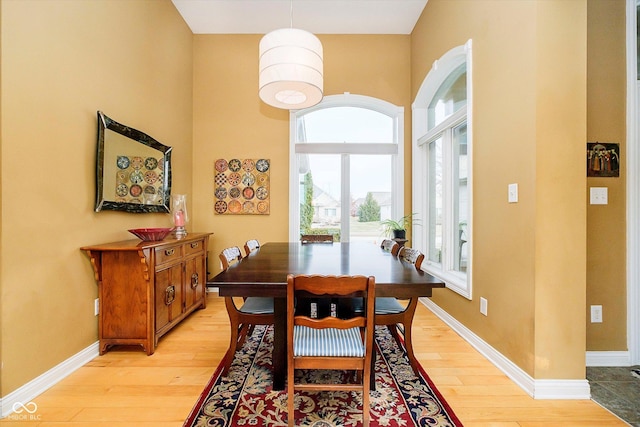 dining room featuring light wood-type flooring and baseboards