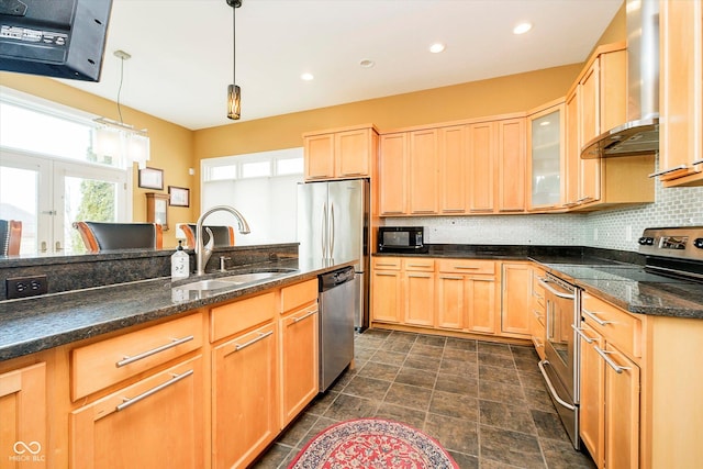 kitchen with light brown cabinets, a sink, appliances with stainless steel finishes, backsplash, and wall chimney exhaust hood