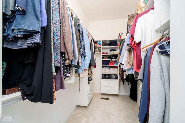 spacious closet featuring light colored carpet