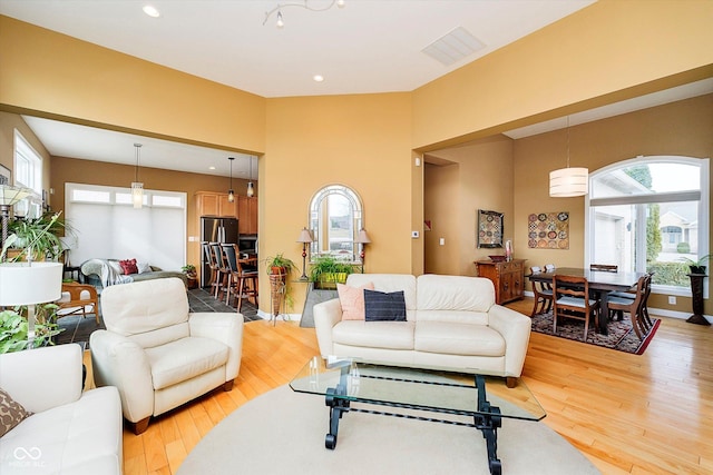 living room with recessed lighting, visible vents, light wood-style flooring, and baseboards