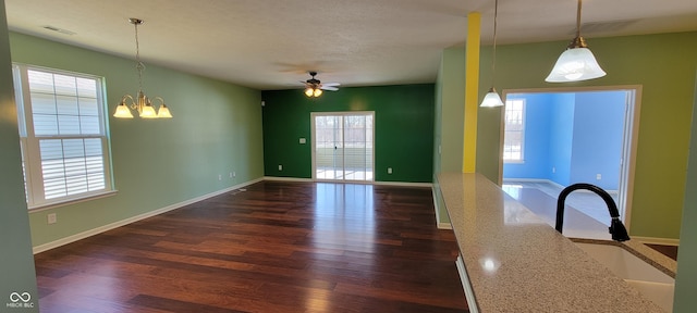 unfurnished dining area featuring visible vents, a sink, dark wood finished floors, and baseboards