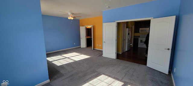 unfurnished bedroom featuring carpet flooring, fridge with ice dispenser, baseboards, and ceiling fan