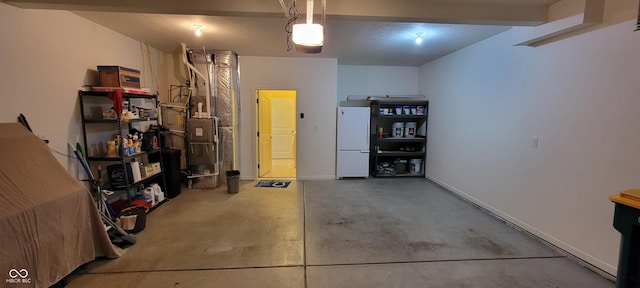 garage with baseboards, a garage door opener, and freestanding refrigerator