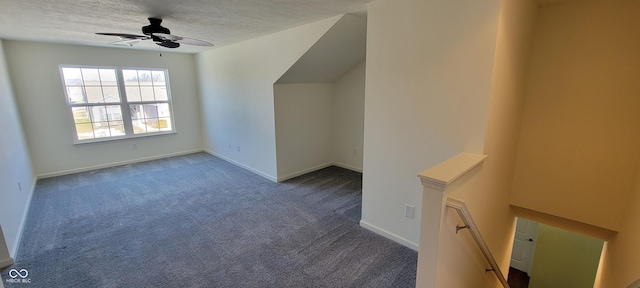 additional living space featuring carpet, baseboards, ceiling fan, and a textured ceiling