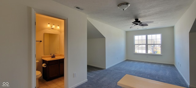 bonus room featuring light carpet, baseboards, visible vents, ceiling fan, and a sink