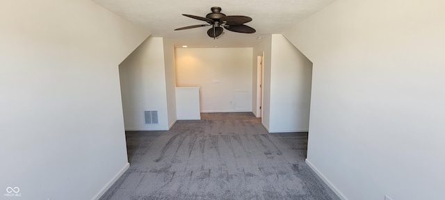 additional living space with baseboards, a ceiling fan, visible vents, and light colored carpet