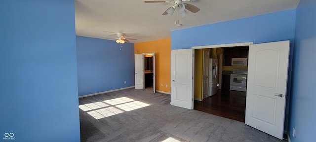 unfurnished bedroom with carpet floors, stainless steel refrigerator with ice dispenser, baseboards, and a ceiling fan