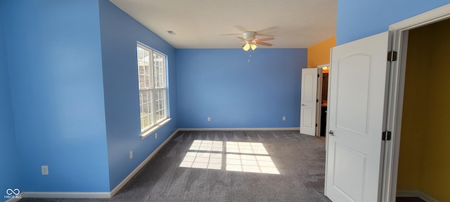 unfurnished bedroom featuring dark colored carpet, a ceiling fan, visible vents, and baseboards