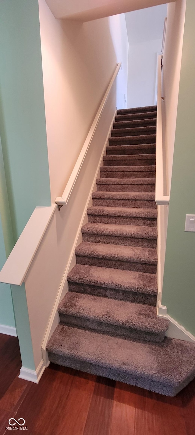 stairs with baseboards and wood finished floors