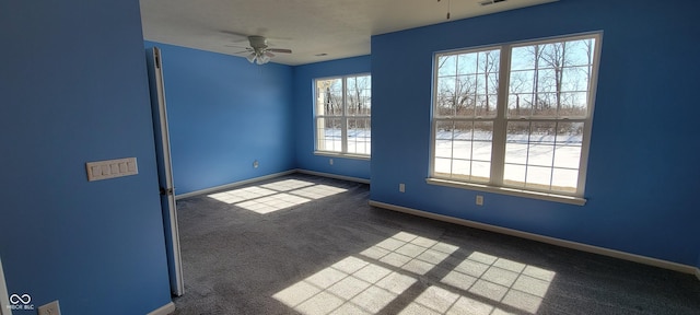 carpeted spare room with visible vents, ceiling fan, and baseboards