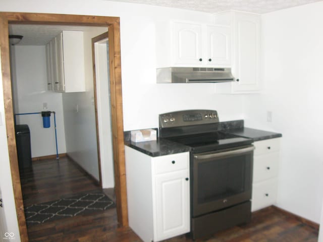 kitchen featuring dark wood finished floors, dark countertops, white cabinetry, range with electric cooktop, and under cabinet range hood