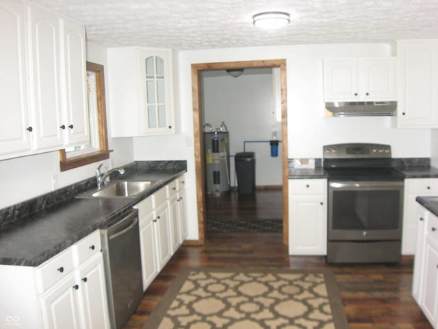 kitchen with water heater, appliances with stainless steel finishes, glass insert cabinets, white cabinetry, and under cabinet range hood