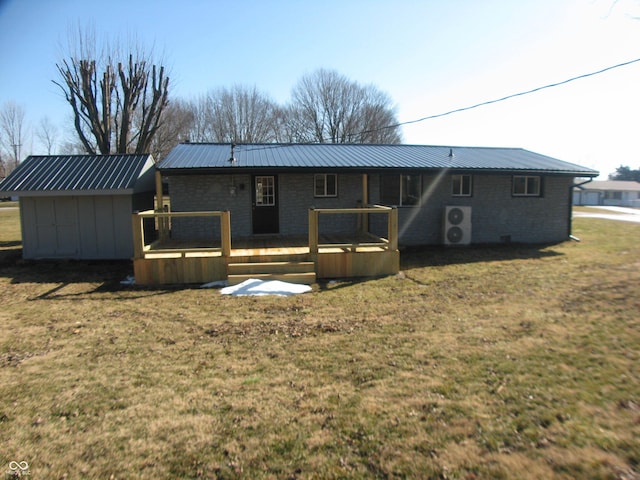 rear view of property with metal roof, an outbuilding, a deck, and a yard