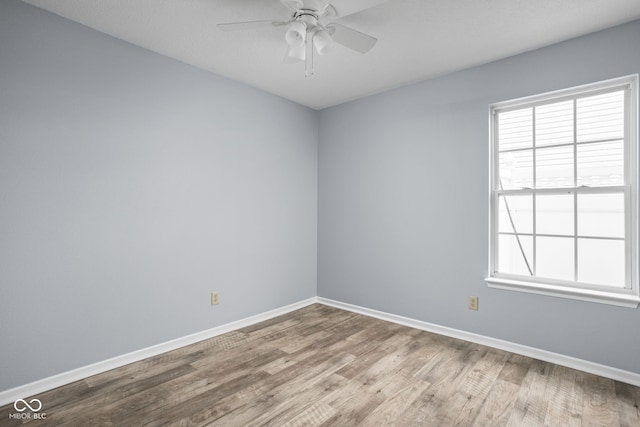 spare room featuring a ceiling fan, baseboards, and wood finished floors