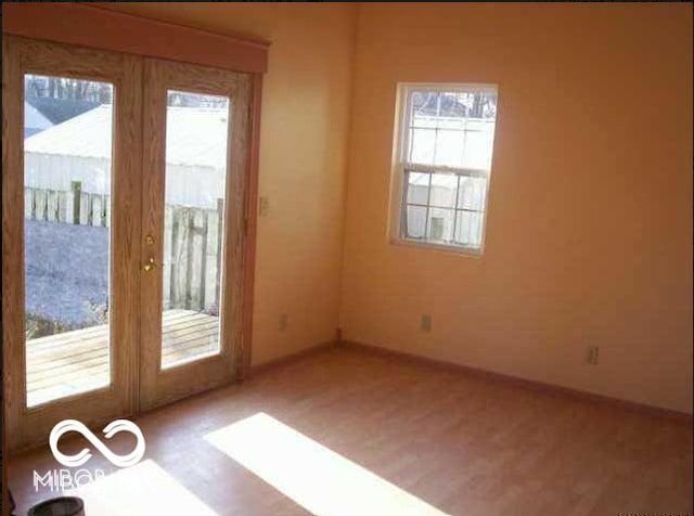 unfurnished room featuring baseboards and wood finished floors