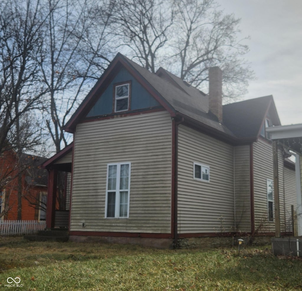 view of side of home featuring a yard and a chimney