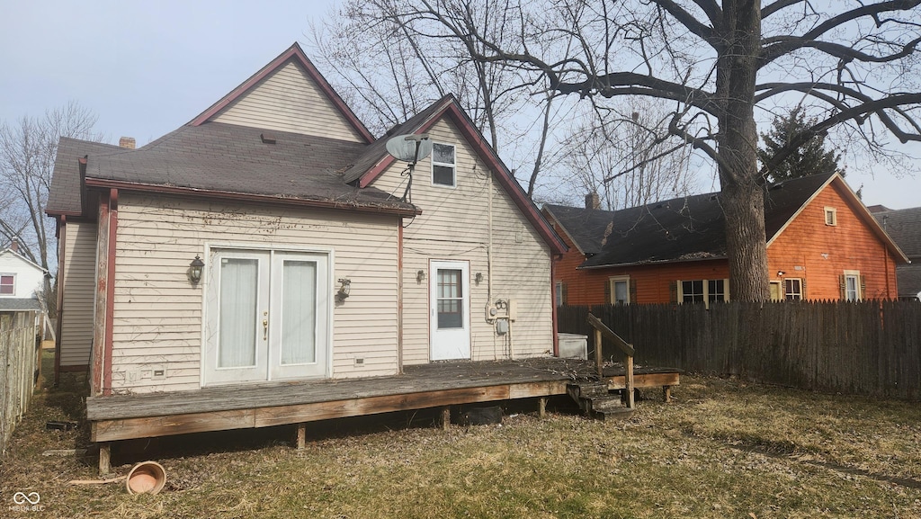 rear view of property featuring french doors, fence, and a wooden deck