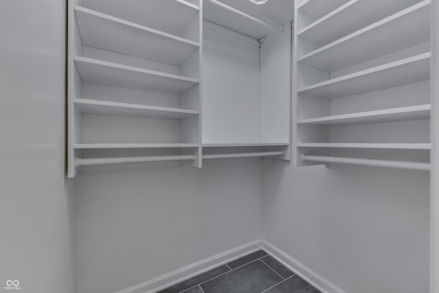 walk in closet featuring dark tile patterned floors