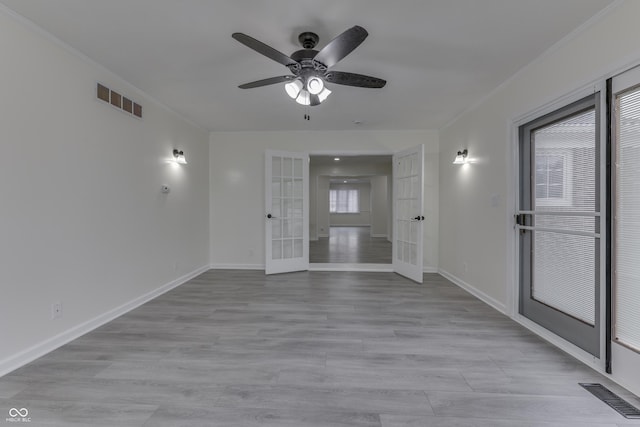 unfurnished room featuring light wood-type flooring, french doors, and visible vents