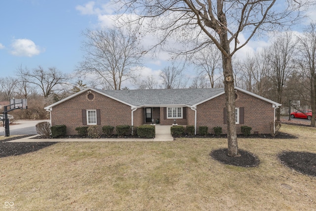 single story home with brick siding, a shingled roof, and a front yard