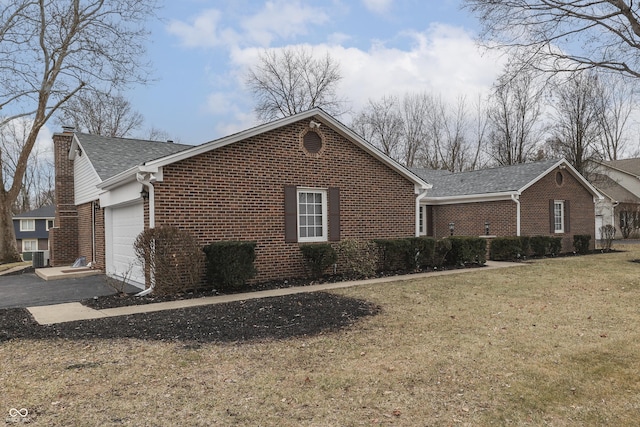 view of home's exterior featuring a garage, driveway, a chimney, a yard, and brick siding