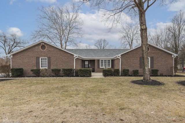 single story home with a front lawn, a shingled roof, and brick siding