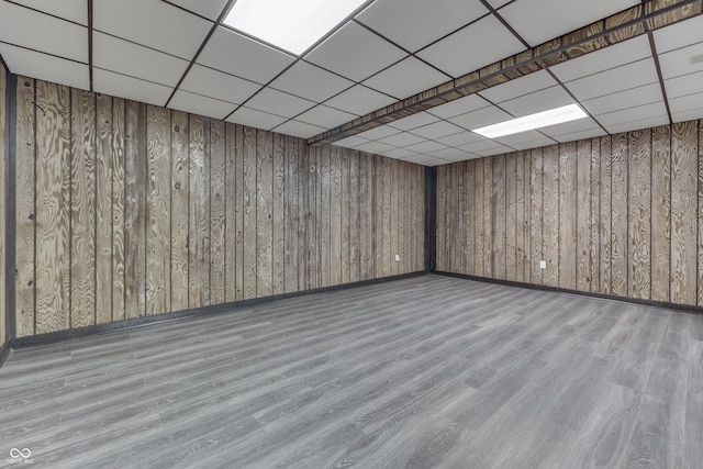 finished basement featuring a paneled ceiling and wood finished floors