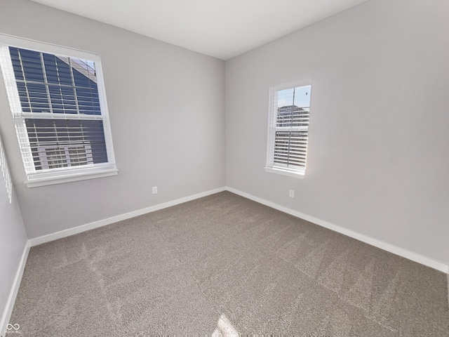 spare room featuring carpet floors and baseboards