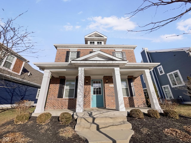 american foursquare style home with a porch and brick siding