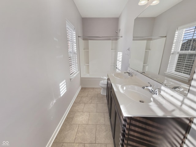 full bath with double vanity, a sink, toilet, and baseboards