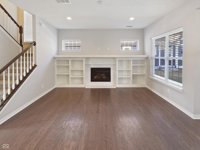 unfurnished living room with visible vents, baseboards, dark wood finished floors, a fireplace, and recessed lighting