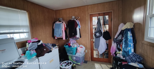 entryway featuring wooden walls and independent washer and dryer