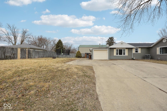 exterior space with a lawn, concrete driveway, a trampoline, fence, and cooling unit