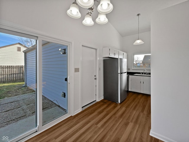 kitchen featuring dark wood-type flooring, a sink, white cabinetry, freestanding refrigerator, and dark countertops