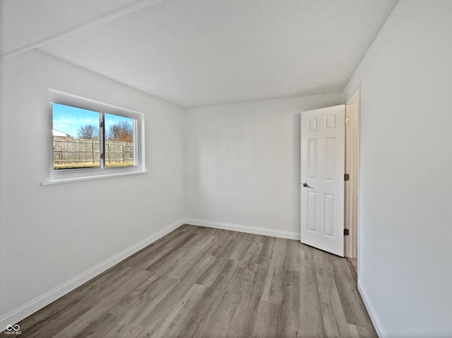 empty room featuring baseboards and wood finished floors