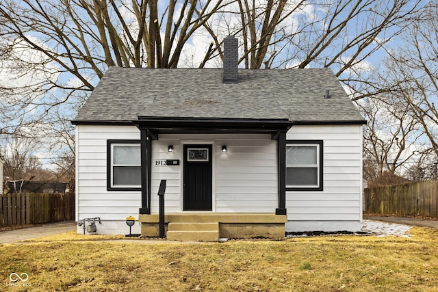 bungalow with a shingled roof, entry steps, and fence