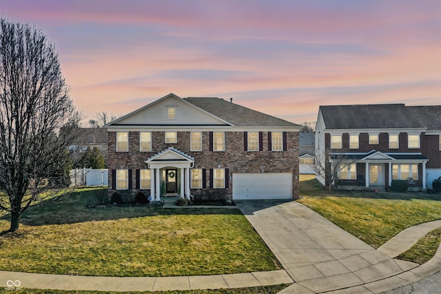 view of front of house with a front yard, concrete driveway, fence, and an attached garage